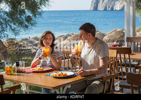 Junges Paar im beach cafe Spaß beim essen Dessert mit frischem Obst Stockfoto