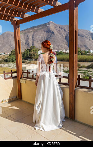 Braut im weißen Kleid auf der Veranda Stockfoto