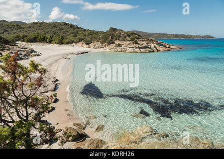 Lichtdurchlässig und türkisblaue Mittelmeer Läppen vorsichtig auf eine einsame Sandstrand von einem Felsvorsprung an der Küste von der Wüste des grenzt Agri Stockfoto