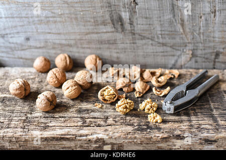 Leckere Nüsse und Nussknacker auf einem alten Holztisch, Zusammensetzung, Copyspace Stockfoto