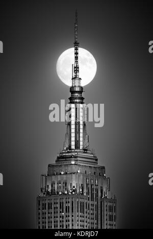 HOBOKEN, NJ - 13. NOVEMBER 2016: Vollmond steigt auf und richtet sich an die Spitze des Empire State Building. Stockfoto