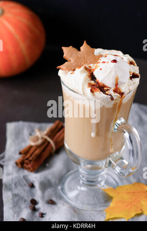 Pumpkin spice Latte mit Schlagsahne, Karamel Sirup und Marshmallows in einem Becher mit Lebkuchen cookie eingerichtet. Herbst Komfort Essen Stockfoto