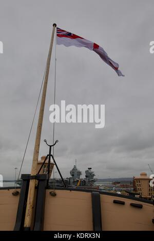 Ein Blick auf die HMS Queen Elizabeth neue Flugzeugträger der Royal Navy Form der Stern der HMS VICTORY in Portsmouth Historic Dockyard Stockfoto