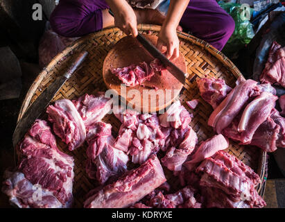 Eine Frau Metzger schneiden und Vorbereitung von Schweinefleisch in Dong Ba Markt, Hue, Vietnam Stockfoto