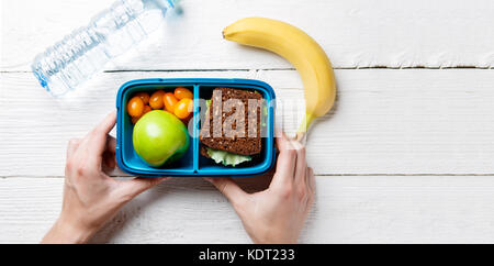 Foto der Hände des Menschen mit nützlichen Mittagessen in Feld Stockfoto