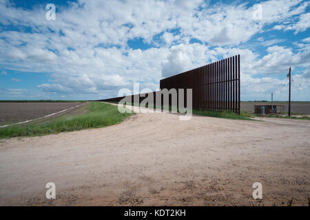 Texas Grenzzaun sitzt auf einem Deich, in der Nähe von Texas an der mexikanischen Grenze. Dieser Teil des Zauns wurde während der Ära George W. Bush. Der Zaun und Dik Stockfoto