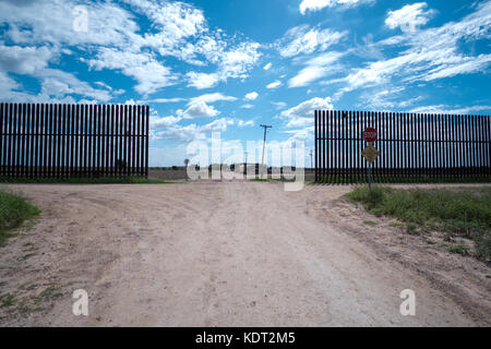 Texas Grenzzaun sitzt auf einem Deich, in der Nähe von Texas an der mexikanischen Grenze. Dieser Teil des Zauns wurde während der Ära George W. Bush. Der Zaun und Dik Stockfoto