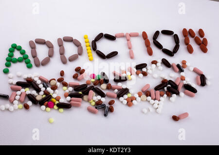 Hand schreiben Bildunterschrift Inspiration medical care Konzept mit Pillen, Drogen geschrieben Kapsel Wort Drogensucht auf weißem Hintergrund isoliert mit spac Stockfoto