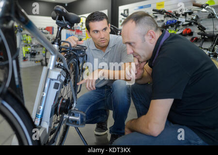 Man prüft Fahrrad vor dem Kauf im Sportgeschäft Stockfoto