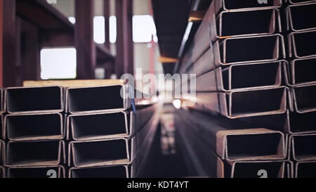 Metal pipe profile and sun in the background. Sheet metal profiles transporting, close up. Metal or aluminum profile channel for use in structures, warehouse. Bent metal profile channel. Factory Stockfoto
