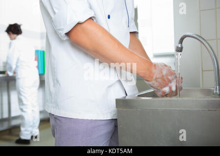 Man Waschen der Hände in der Küche Stockfoto