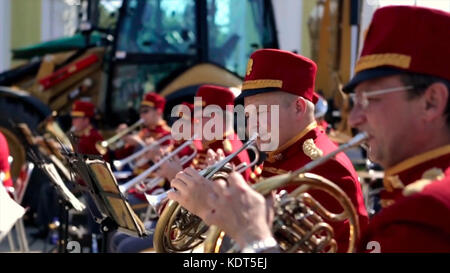 Russland, Moskau - 12. Juni 2017: Bandmeister auf einer Trompete. Bandwalas spielen auf ihren Instrumenten im Park. Männer in Rot spielen die Trompete aus der Nähe. Stockfoto