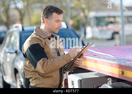 Tow Truck Driver herauf gebrochen Auto Stockfoto