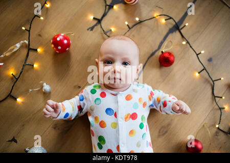 Kleines Baby auf dem Boden an Weihnachten liegen. Hohe Betrachtungswinkel. Bis zu schließen. Stockfoto