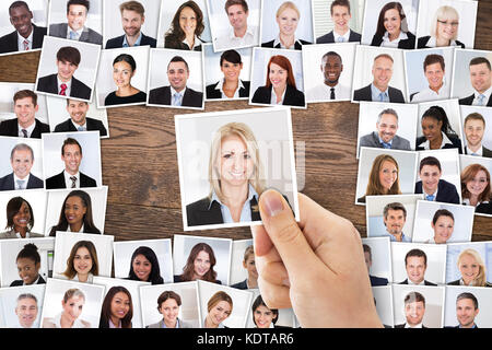 Hohe Betrachtungswinkel der Person Hand Auswahl der weiblichen Bewerber Portrait Foto für die Einstellung im Job Stockfoto