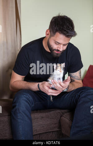 Traumhaft schöne junge Paar hält Katzen in Händen Stockfoto