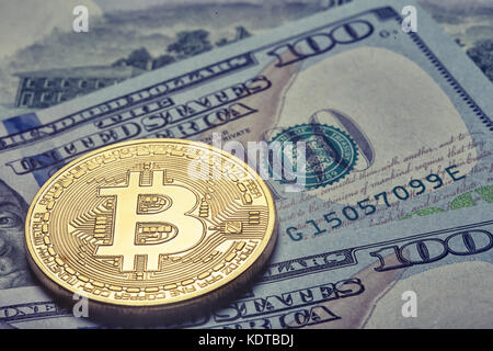 Golden glänzenden Bitcoin auf dem Hintergrund von hundert Dollar bil Stockfoto