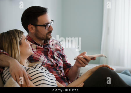 Junges Paar sitzt auf der Couch und Fernsehen Stockfoto