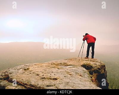 Professionelle Fotografen arbeiten am Berg. Natur Fotograf Fotos mit Spiegel Kamera nimmt auf Felsen über herbstliche Landschaft. verträumte fogy Va Stockfoto