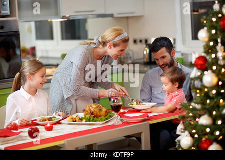 Lächelnde Mutter in der Türkei zu seiner Familie nach Weihnachten das Abendessen serviert Stockfoto