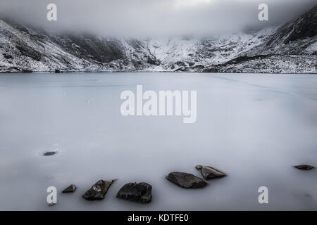 Llyn Idwal mit gefrorenen See und niedrige Nebel im Winter, Ogwen, Wales, UK gebildet Stockfoto