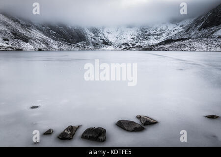 Llyn Idwal mit gefrorenen See und niedrige Nebel im Winter, Ogwen, Wales, UK gebildet Stockfoto