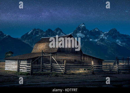 Leichte Farbe auf Thomas Moulton Barn, Teil der Mormon Row im Grand Teton National Park. Auch mit Milchstraße dahinter. Stockfoto