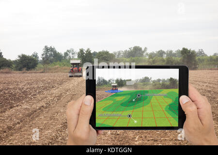 Smart Landwirtschaft Konzept, Landwirt mit Tablet lesen Sie Infrarot in Traktor mit High Definition Bodenkartierung während der Aussaat, tiefen Boden während eines Scans Stockfoto