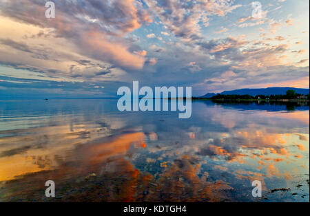 Ein dramatischer Sonnenuntergang im Spiegel das ruhige Wasser von Maria wider, Baie DES Chaleurs, Gaspesie, Quebec, Kanada Stockfoto