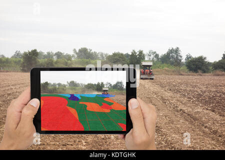 Smart Landwirtschaft Konzept, Landwirt mit Tablet lesen Sie Infrarot in Traktor mit High Definition Bodenkartierung während der Aussaat, tiefen Boden während eines Scans Stockfoto