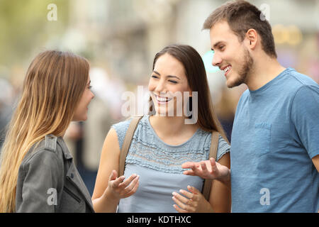 Portrait von drei Lächeln Freunde sprechen gemeinsam auf der Straße Stockfoto