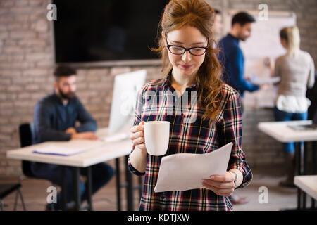 Porträt der jungen Weiblich designer Holding Tasse Kaffee und Stockfoto