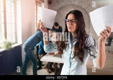 Bild der attraktive junge wütende Frau im Büro Stockfoto