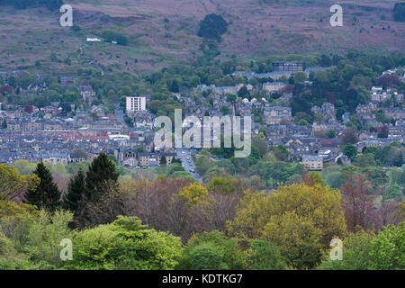 Abendlicher Blick über Wohngebäude und High Street, eingebettet im Tal unter Wharfe moorlandschaften Ilkley Innenstadt, West Yorkshire, England, UK. Stockfoto