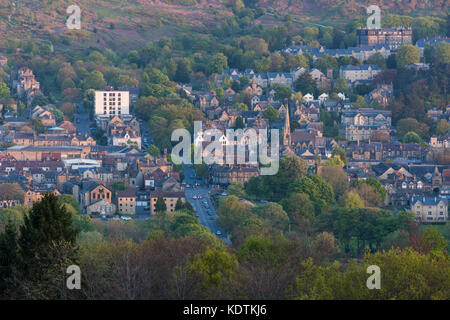 Abendlicher Blick über Wohngebäude und High Street, eingebettet im Tal unter Wharfe moorlandschaften Ilkley Innenstadt, West Yorkshire, England, UK. Stockfoto