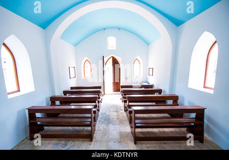 Im Interieur des kleinen generische Kirche. Türen, Fenster, Holzbänke, Steinfliesen, und Bögen des generischen Dorf katholische Kirche. Stockfoto