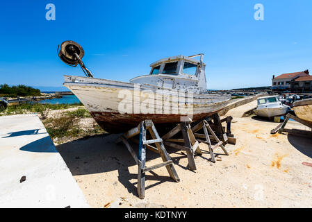 Reparatur und Restauration von alten hölzernen Angeln Schiff oder Boot. alte verwitterte Fischerboot montiert auf Holz- Buchsen für Dry Dock Renovierung und Reparatur mit Stockfoto