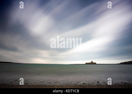 Die St Cwyfan’s Church ist isoliert am horison of the Irish Sea, als der Sturm Ophelia in Anglesey, Nordwales, Anglesey trifft Stockfoto