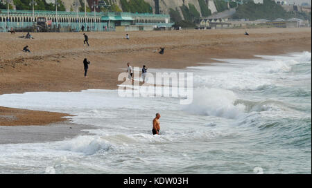 Brighton, uk. 16 Okt, 2017. de Wetter ein Schwimmer Köpfe in das Meer aus Brighton Beach einen ungewöhnlich warmen und sonnigen Herbsttag mit Temperaturen über 20 Grad. In der Zwischenzeit Irland und der Westküste von Großbritannien stützen sich auf die Ankunft der Schwanz Ende der Hurrikan Ophelia 30 Jahre nach dem großen stortm 1987: Simon dack/alamy leben Nachrichten Stockfoto