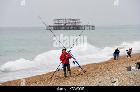 Brighton, uk. 16 Okt, 2017. de Wetter ein Fischer auf Brighton Beach macht das Beste aus einer ungewöhnlich warmen und sonnigen Herbsttag mit Temperaturen über 20 Grad. In der Zwischenzeit Irland und der Westküste von Großbritannien stützen sich auf die Ankunft der Schwanz Ende der Hurrikan Ophelia 30 Jahre nach dem großen stortm 1987: Simon dack/alamy leben Nachrichten Stockfoto