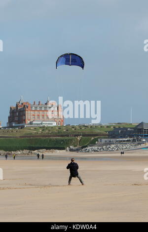 Newquay, Großbritannien. Oktober 2017. Wetter in Großbritannien. Starke Offshore-Winde vom Ex-Orkan Ophelia blasen die hohe Brandung an der Nordküste von Cornwall am Fistral Beach zurück. Ein Mann fliegt einen Drachen in den starken Winden. Kredit: Nichola Burningham/Alamy Live Nachrichten Stockfoto