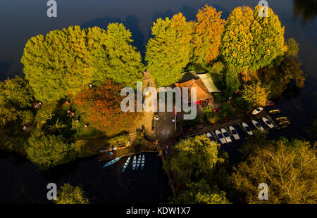 Hamburg, Deutschland. Oktober 2017. Ausflugsboote liegen zwischen herbstlich gefärbten Bäumen am Ufer des Stadtparksees in Hamburg, Deutschland, 16. Oktober 2017. (Foto wurde mit einer Drohne aufgenommen) Credit: Axel Heimken/dpa/Alamy Live News Stockfoto