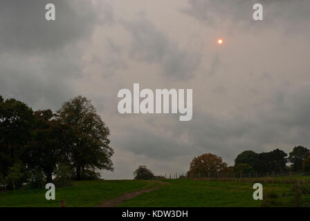 London, Großbritannien. 16. Oktober 2017. Die Auswirkungen von Hurrikan Ophelia auf London Wetter war am Nachmittag Sonne rot und der Himmel eine seltsame rosa. von Hampstead Heath gesehen. Credit: Maggie Sully/alamy Leben Nachrichten. Stockfoto