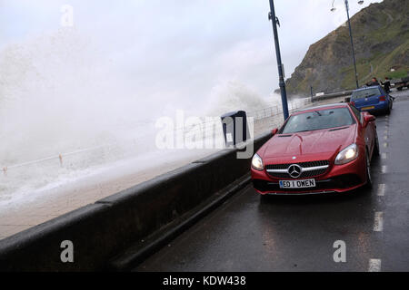 Aberystwyth, Ceredigion, Wales, UK-Flut kommt mit Sturm Ophelia offshore über die Irische See-Wellen auf dem Meer und diese geparkten Mercedes Sportwagen-stong Winde in Aberystwyth auf der West Wales Küste als Sturm Ophelia Ansätze aus der Irischen See mit lokalen Winden von mehr als 50 km/h. Foto Steven Mai/Alamy leben Nachrichten Stockfoto