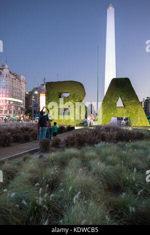 Touristen posieren für Fotos vor dem Obelisken auf der Plaza de La Republica, Buenos Aires, Argentinien Stockfoto