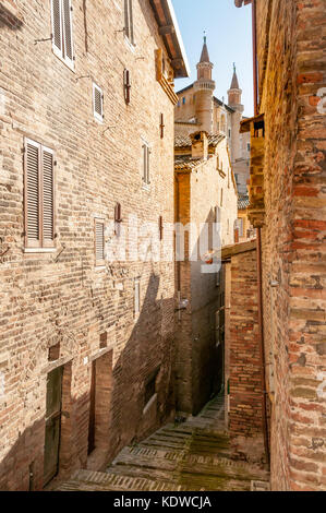 Die Renaissance von Urbino, Marken, Italien. einen Blick auf den Palazzo Ducale (Dogenpalast) aus einer engen Straße in Urbino, Marken, Italien Stockfoto