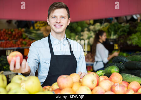 Lächelnd Material in Schürze verkaufen Süße saisonal Äpfel am Marktplatz Stockfoto