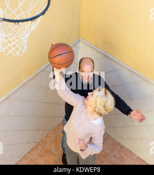Freundliche paar Rentner Basketball spielen in Terrasse Stockfoto