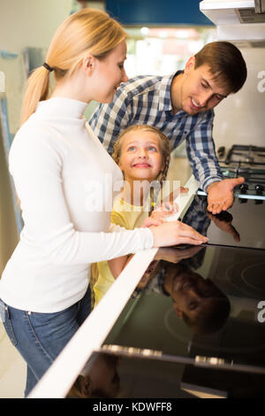 Portrait von Happy Family Auswahl Küche Herd im Gerät speichern. Fokus auf Mädchen Stockfoto