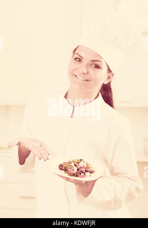 Brunette Mädchen Chef zeigen, Daumen hoch und die Platte mit Salat Stockfoto